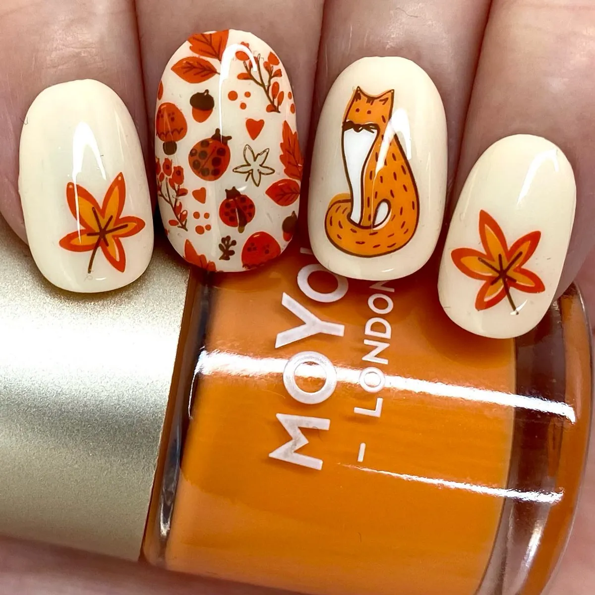 Cream nails with orange leaf motifs and fox illustration