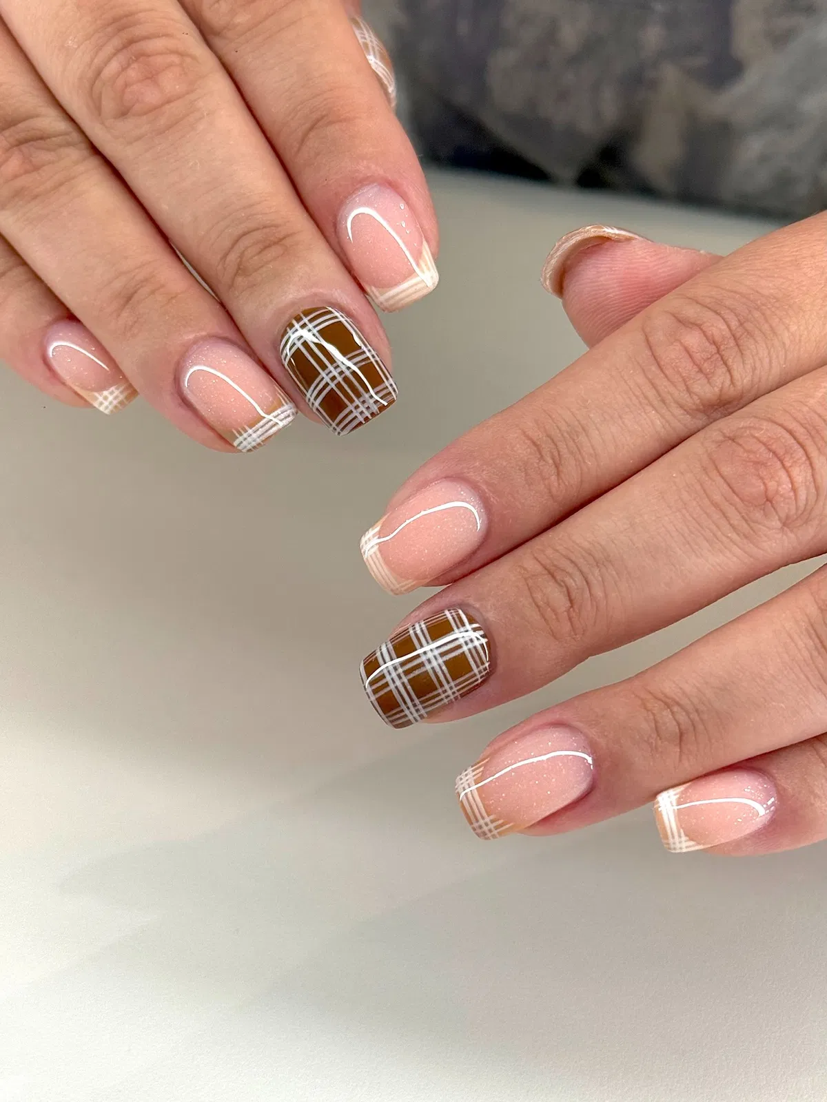 Sheer nude with fine white French tips and brown plaid accents