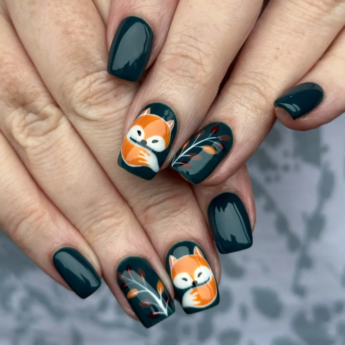 Dark teal nails with fox and branch accents
