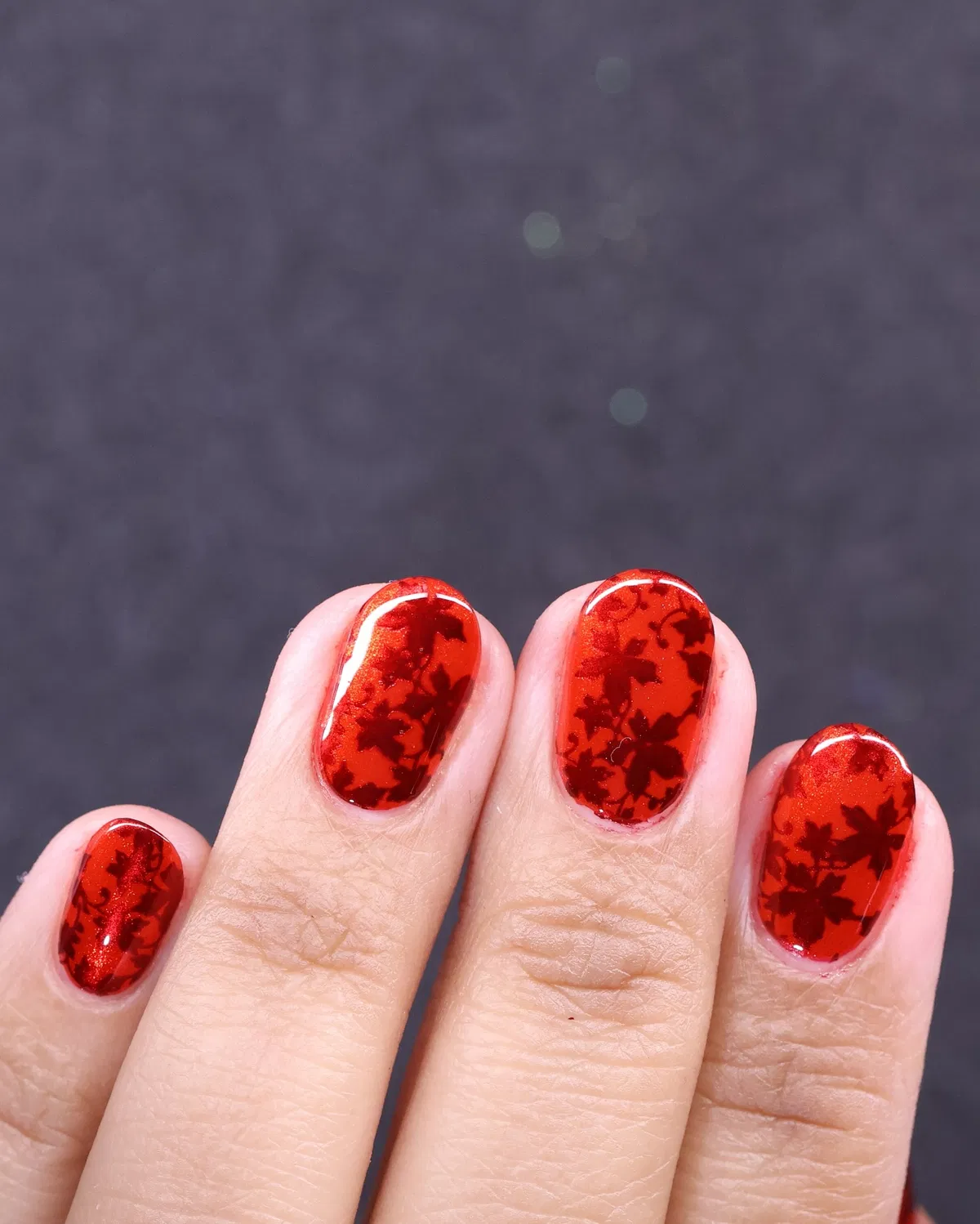 Red leaf-silhouette nails with shimmer