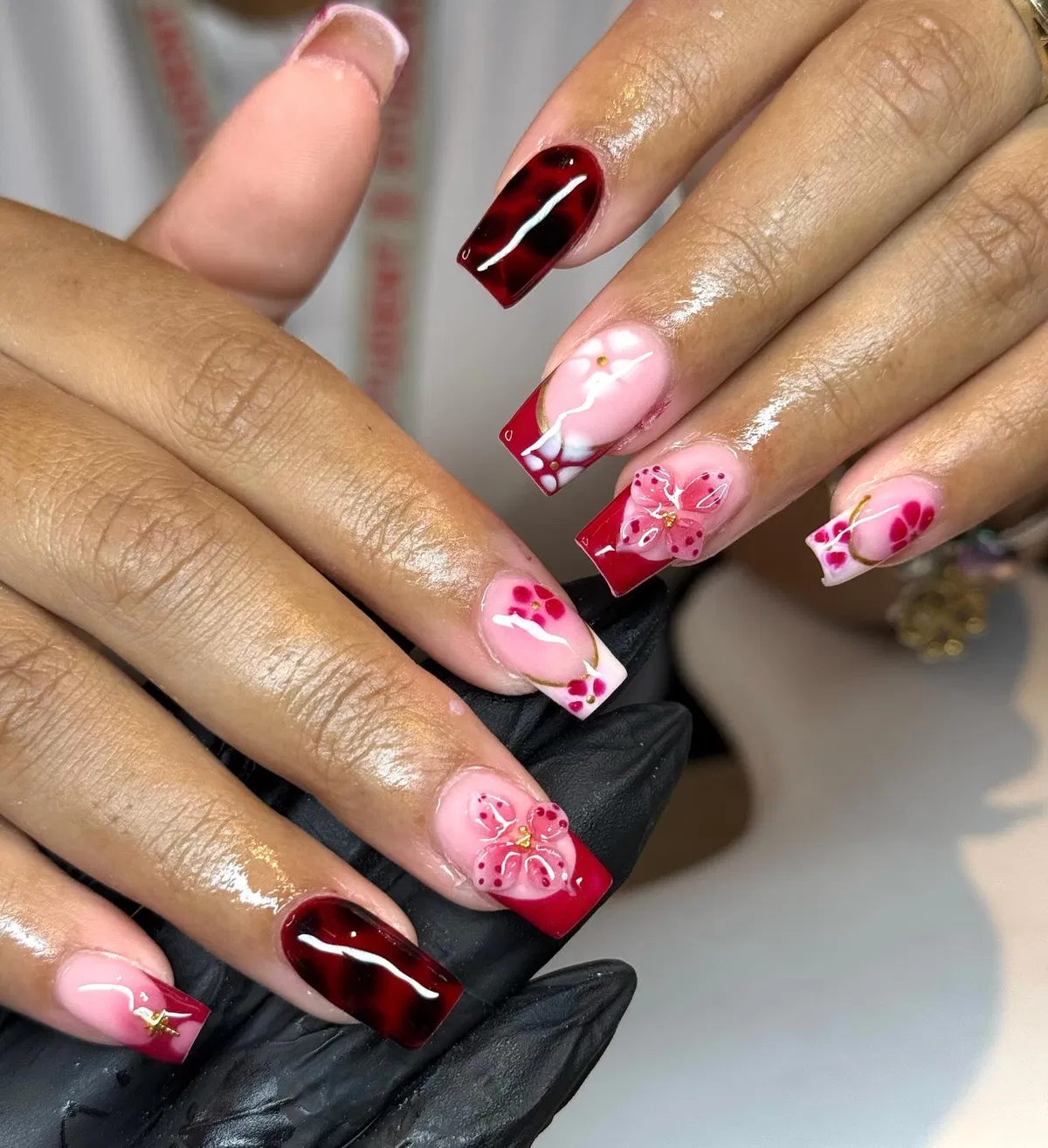 Red French tips, marbled accents, and 3D floral details