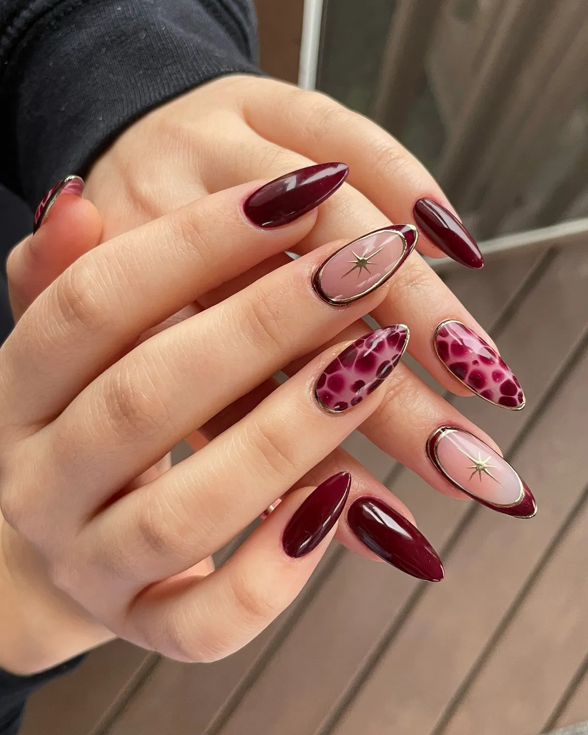 Burgundy almonds with metallic outlines and starburst accents