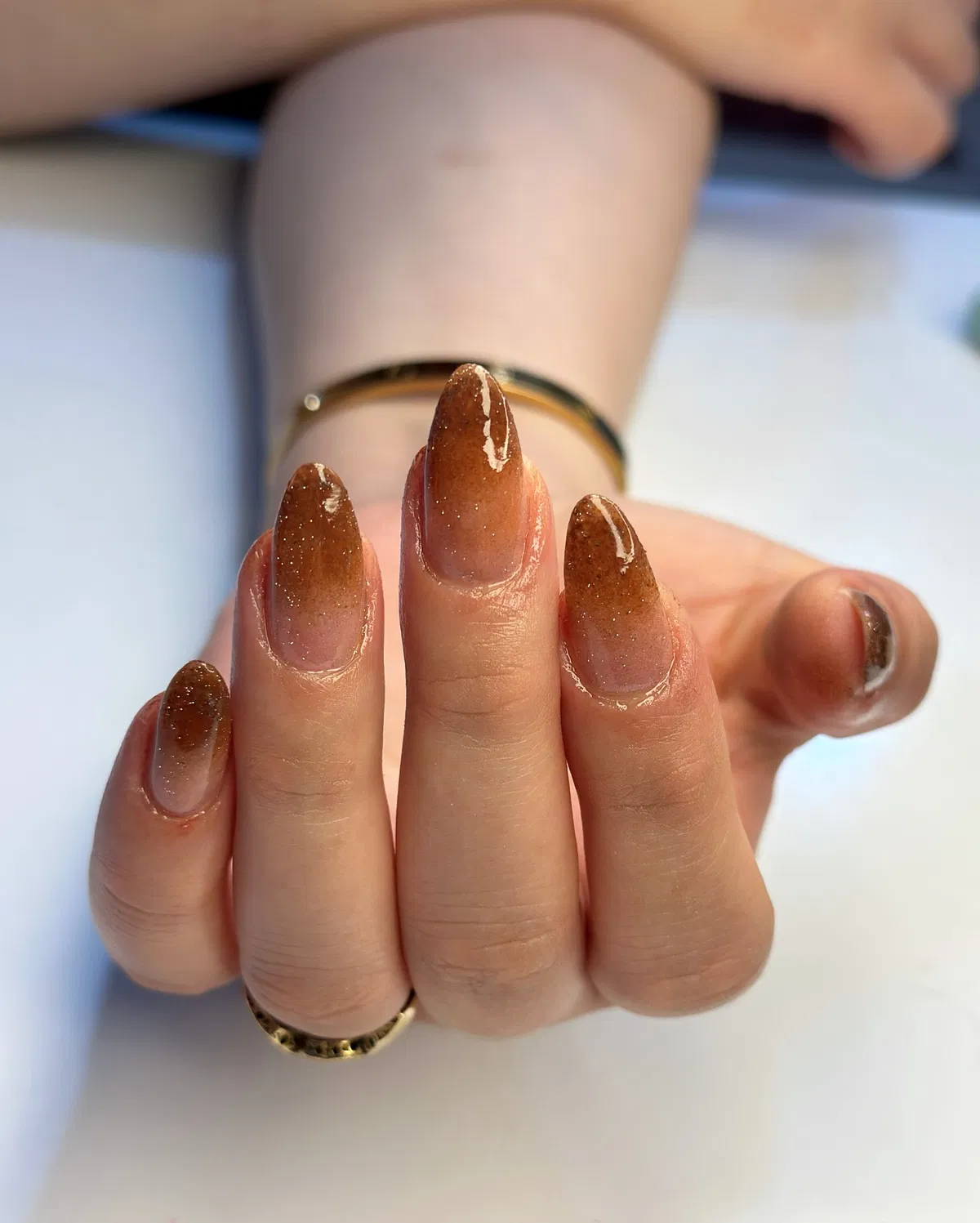 Nude-to-brown glitter ombre almond nails