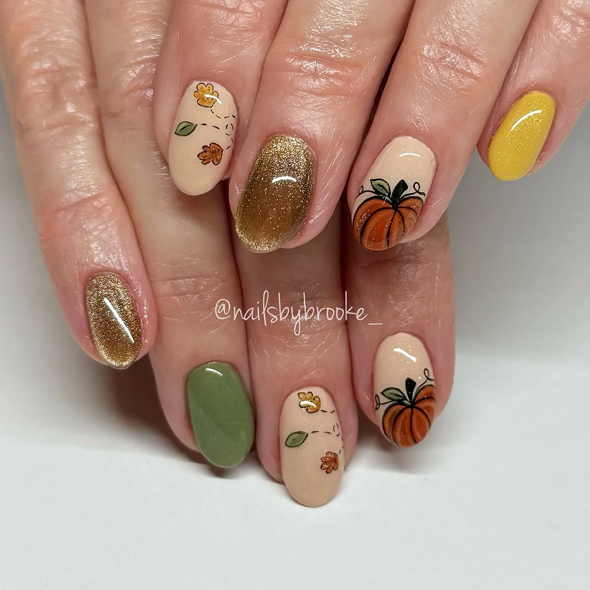 Pumpkin and leaf nail art with gold glitter accents
