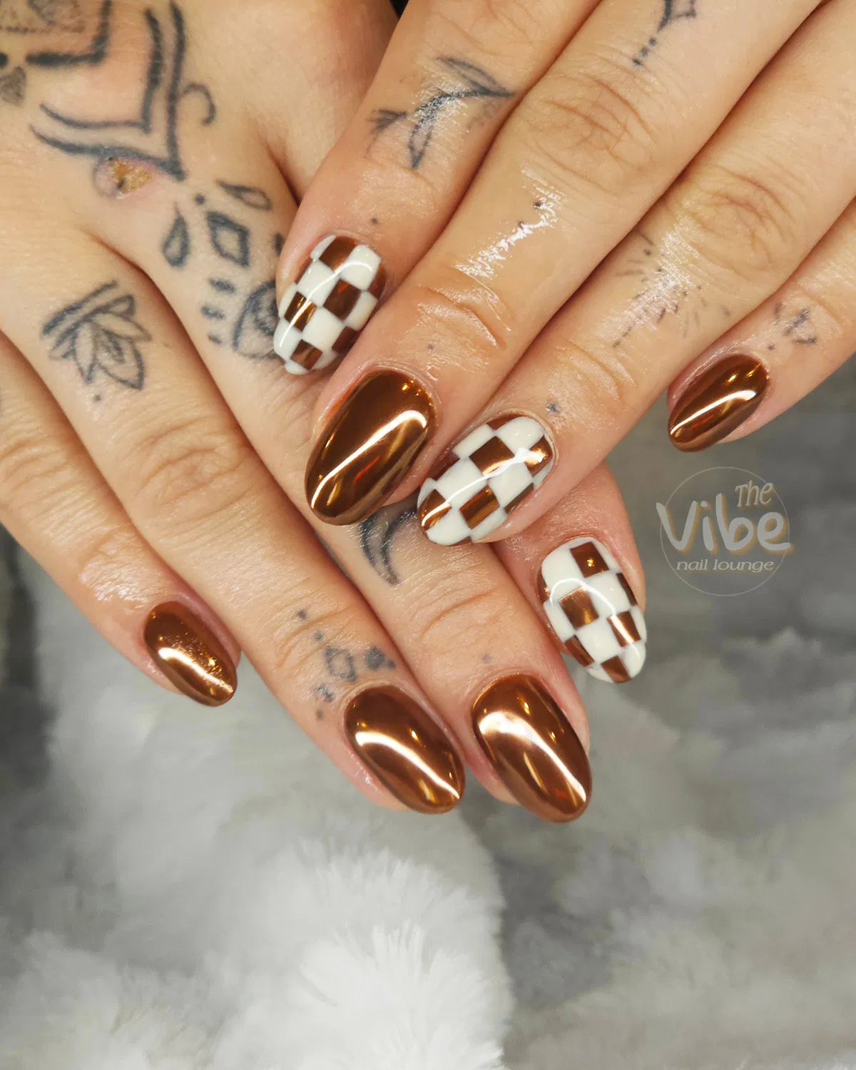 Copper metallic almond nails with checkerboard accents