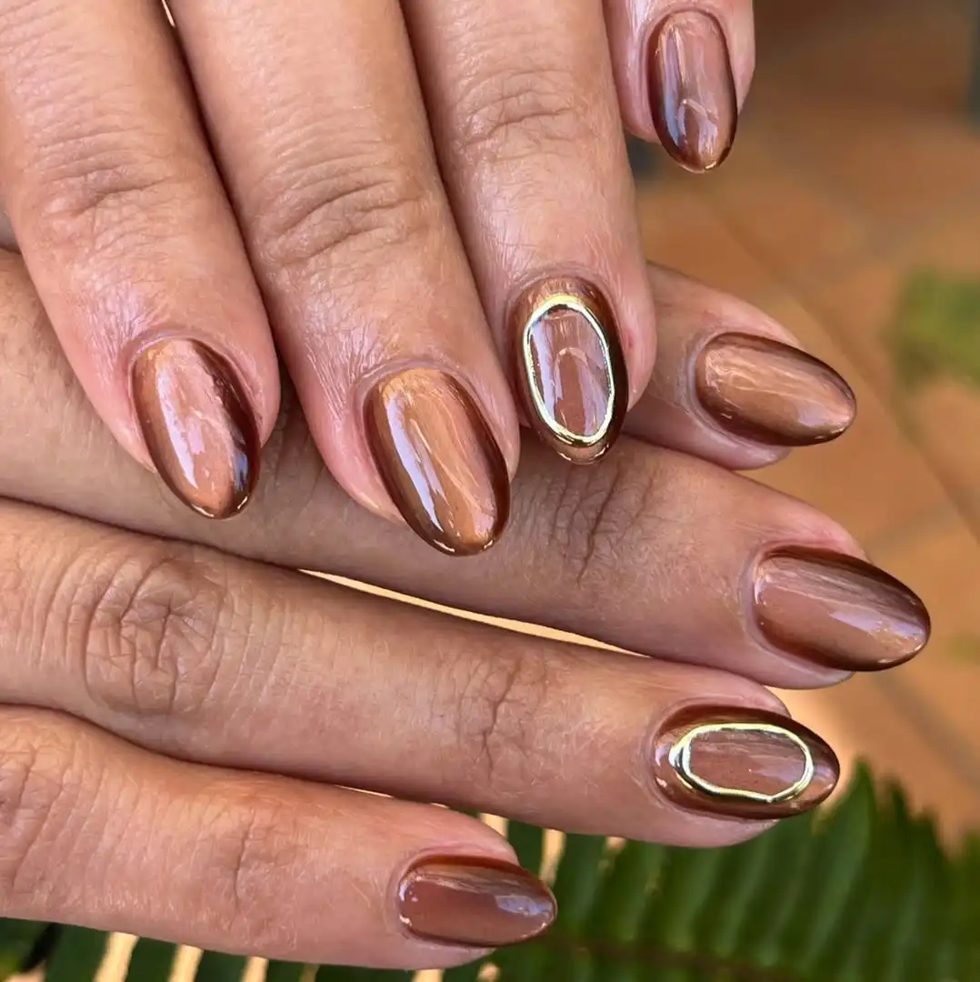 Warm brown metallic nails with raised gold oval frames