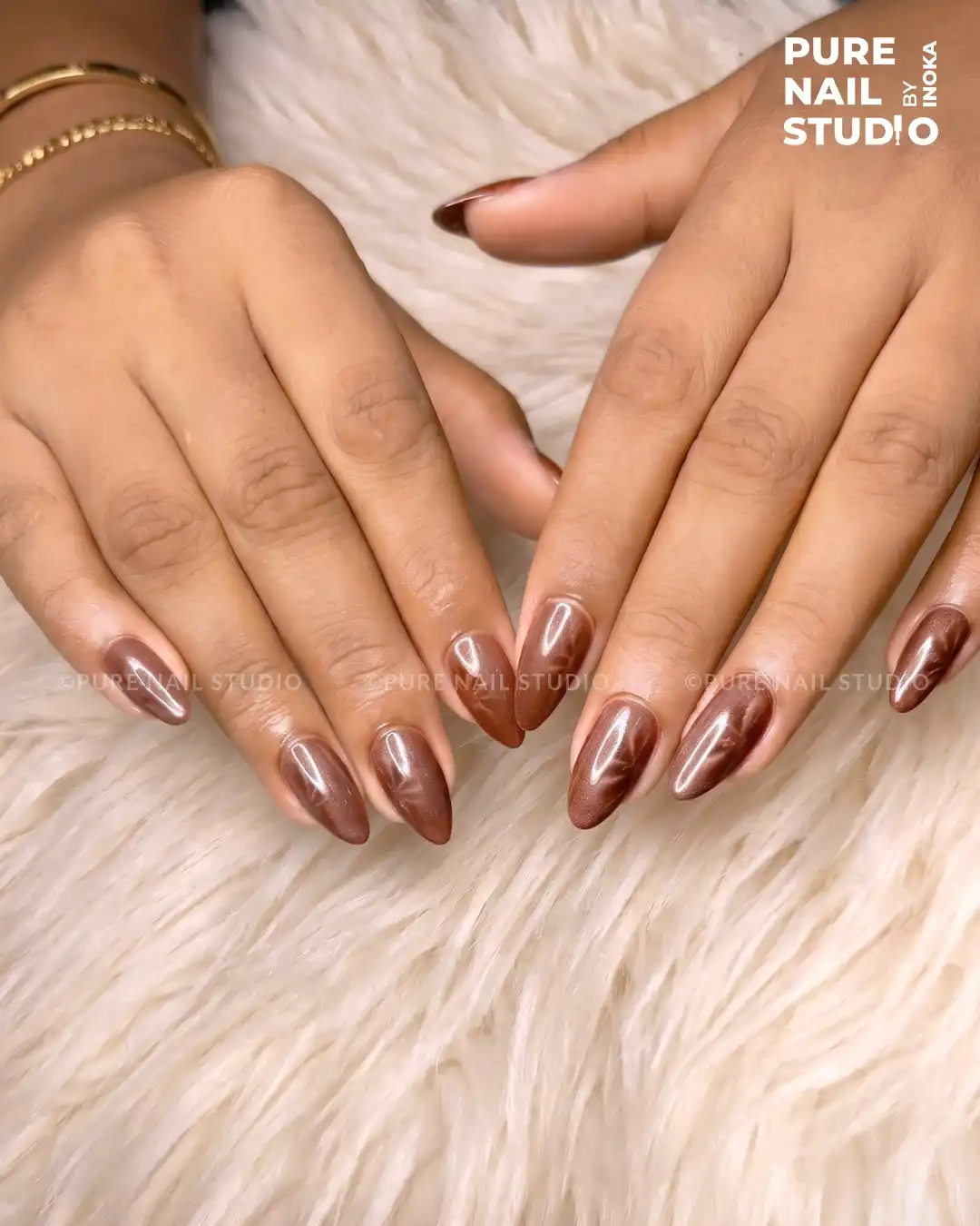 Glossy brown metallic nails with reflective streaks