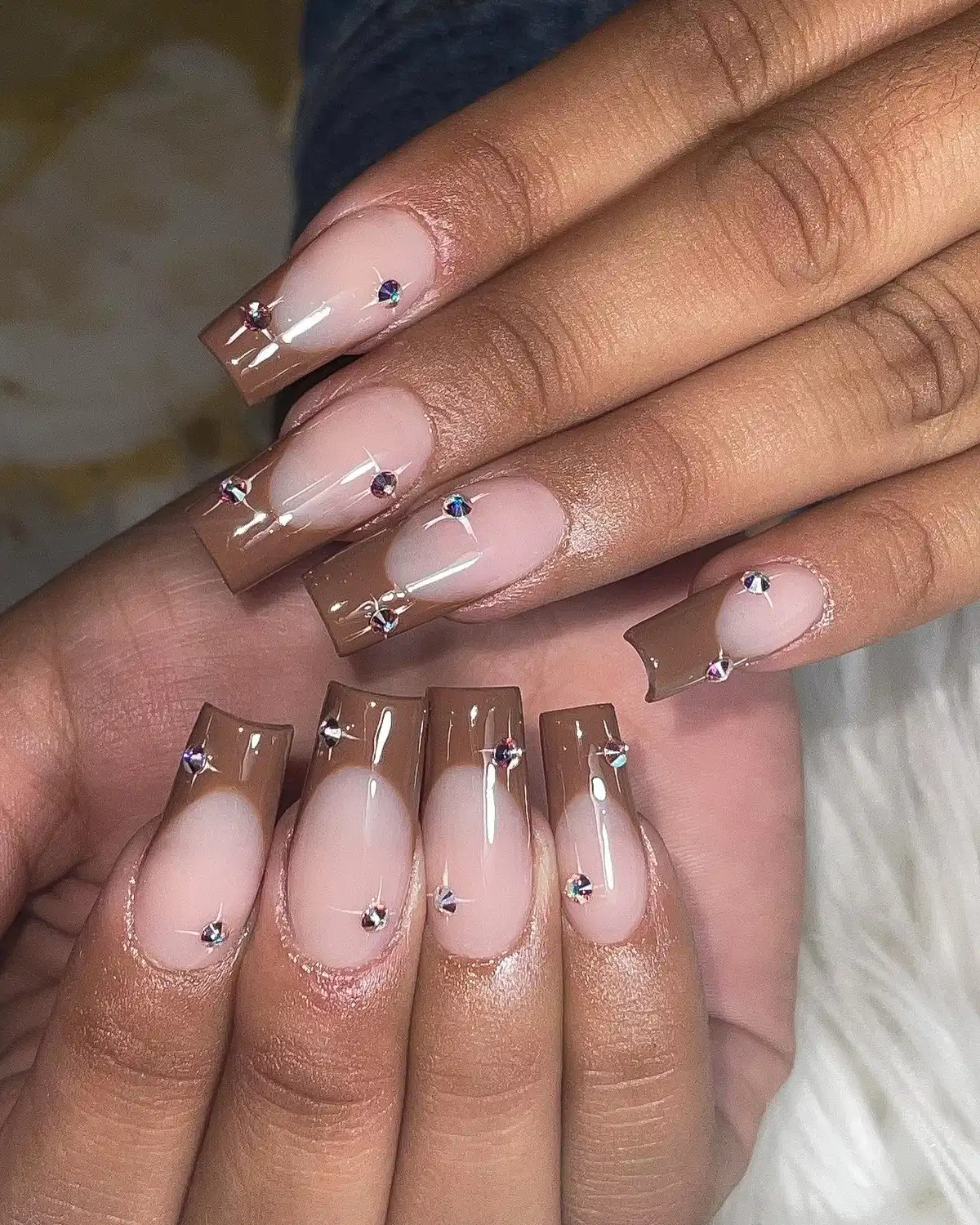 Translucent brown French tips with rhinestone accents