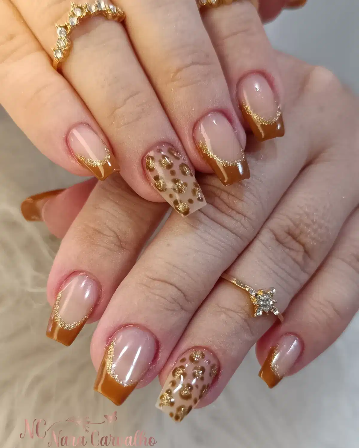 Warm brown French tips with gold glitter and spotted accents