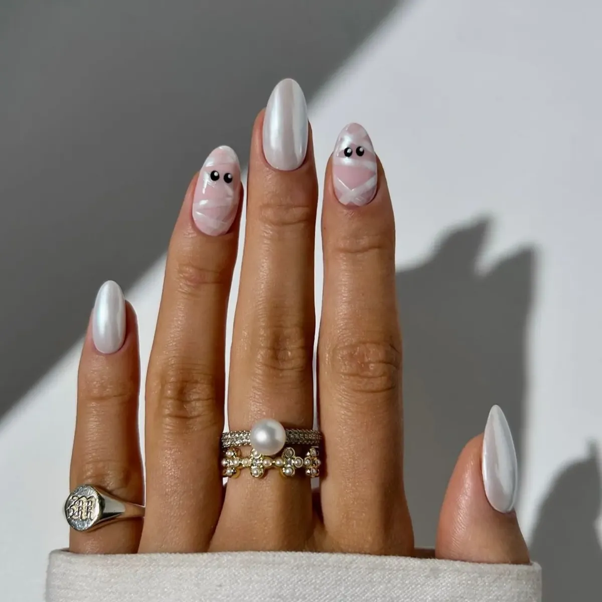 Pearly White Almond Nails with Subtle Wrapped-Eyes Accents