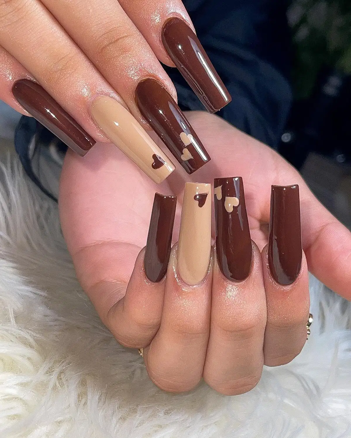 Long glossy dark brown nails with beige heart accents