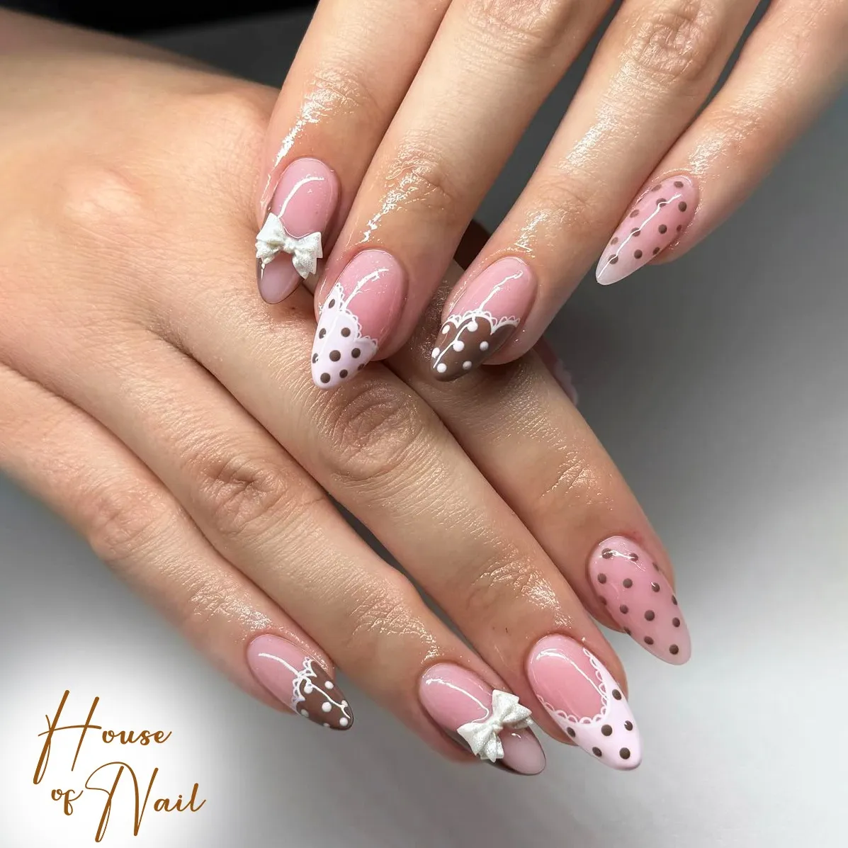 Pink French tips with scallops, dots, and bow accents