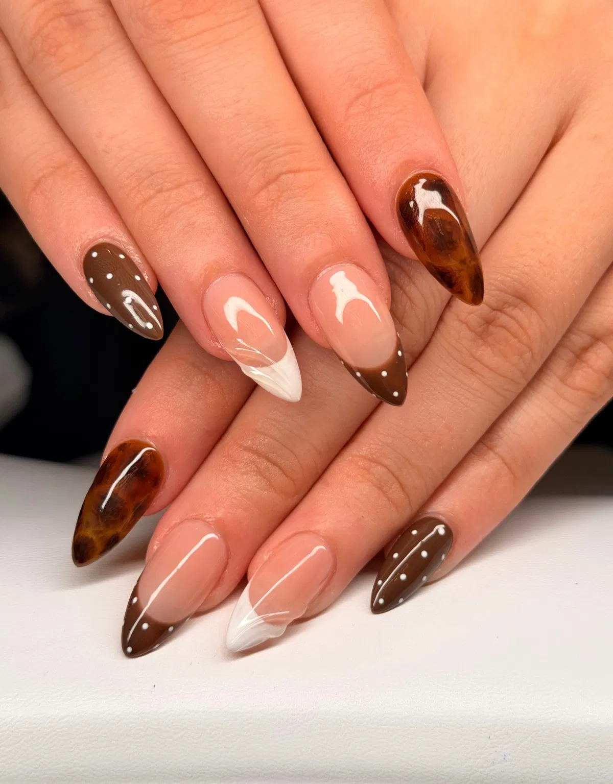 Mixed tips: brown dotted French, tortoiseshell pattern, and white swirls
