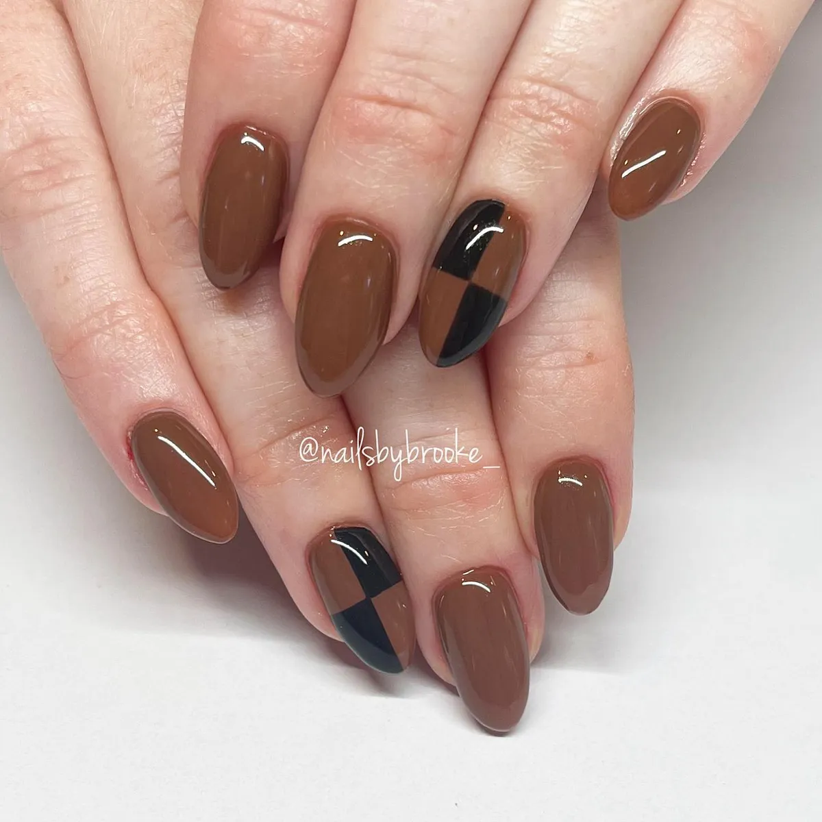 Glossy brown nails with black-and-brown check accents