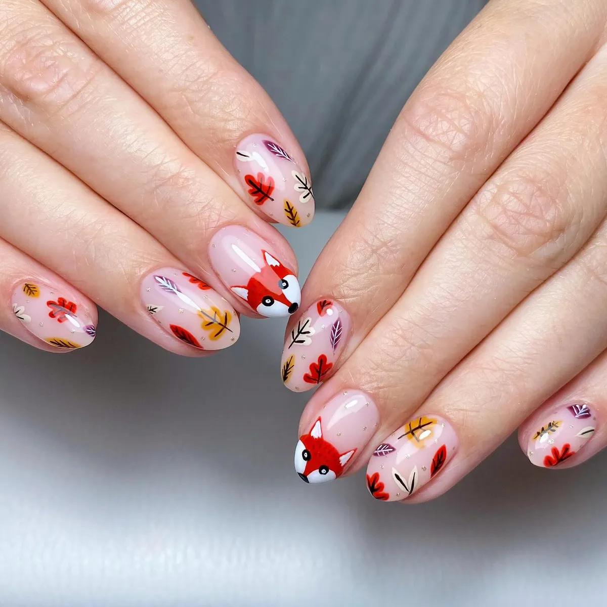 Sheer pink base with multicolor leaves and animal-face accents