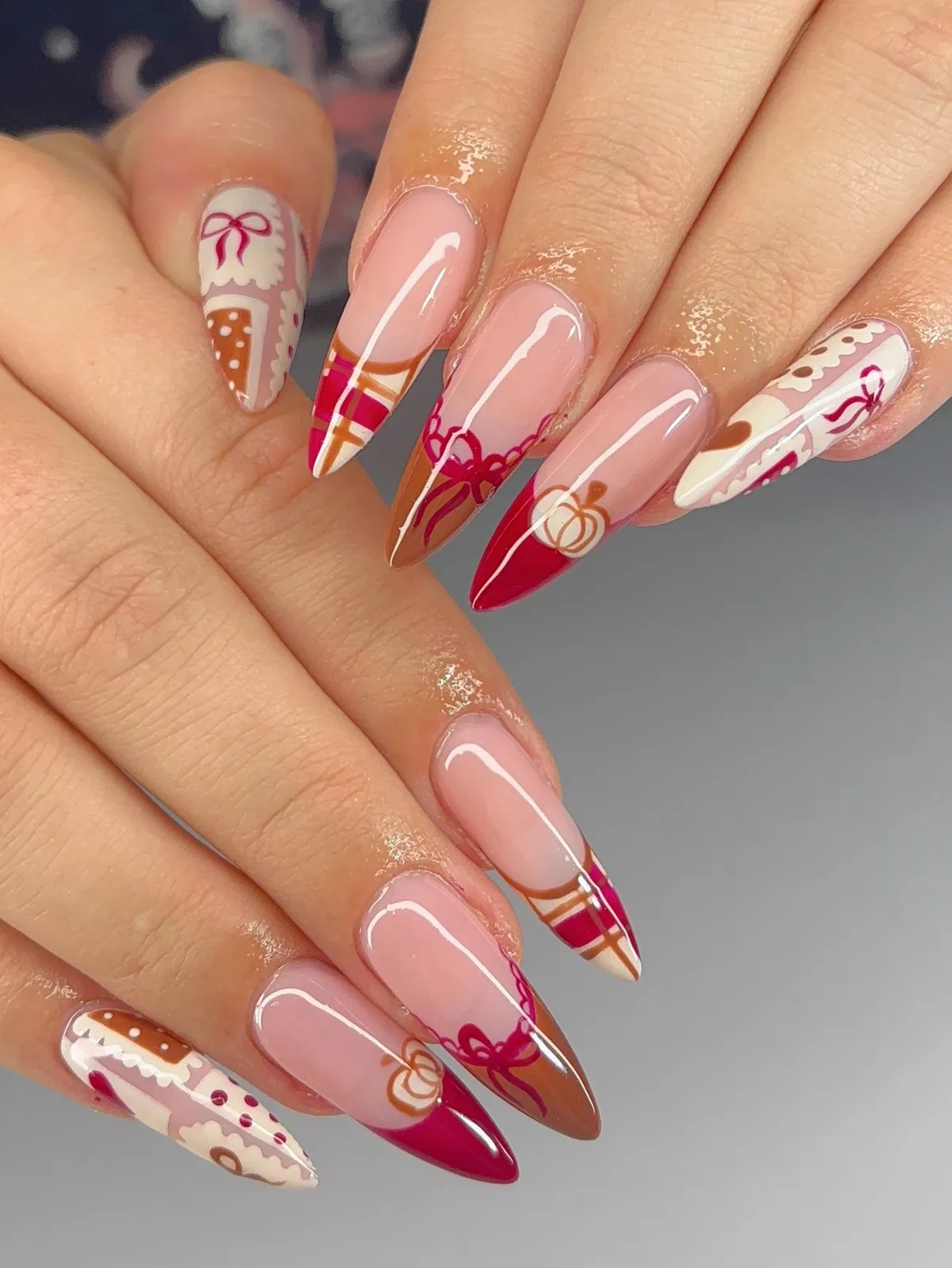 Pink base with red-brown graphic French tips and bows