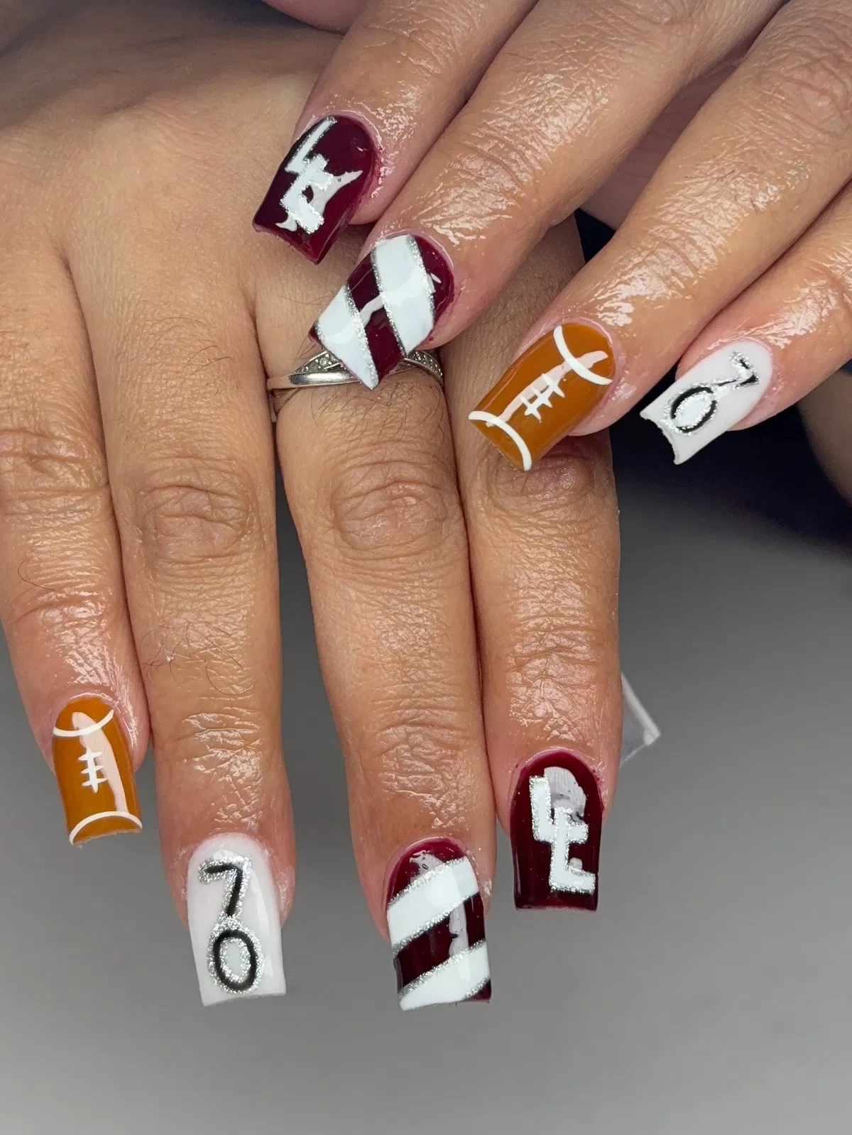Maroon, white, and football-lace accents with bold lettering