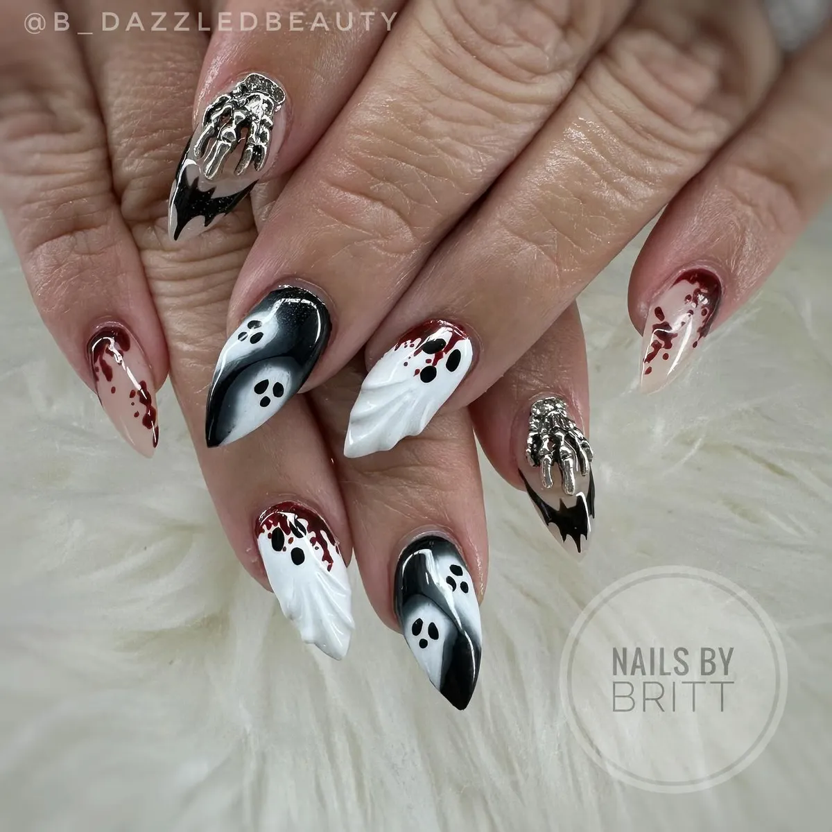 Pointed black-and-white ghosts with red splatter and silver hand charms