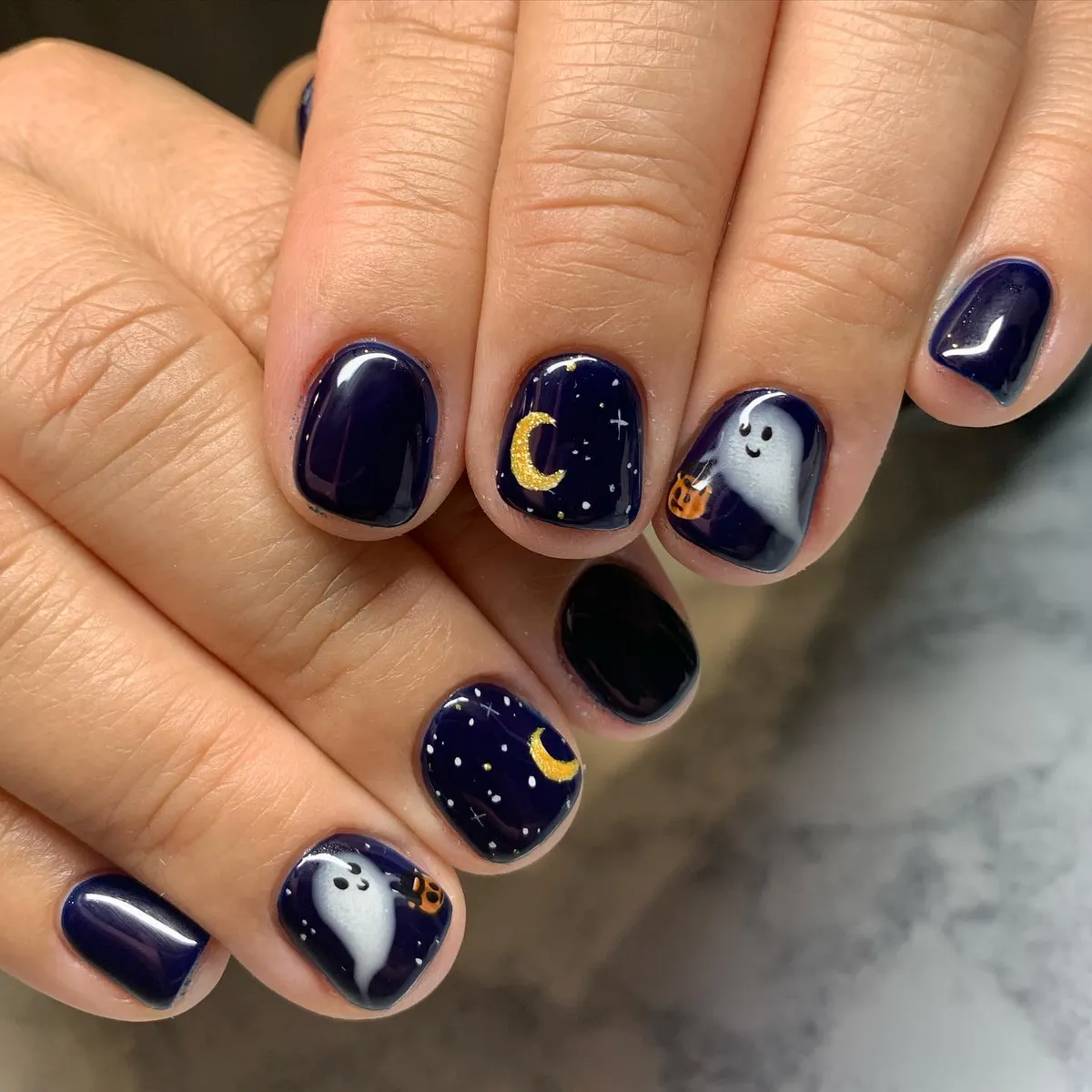 Navy night-sky nails with crescent moons and a ghost accent