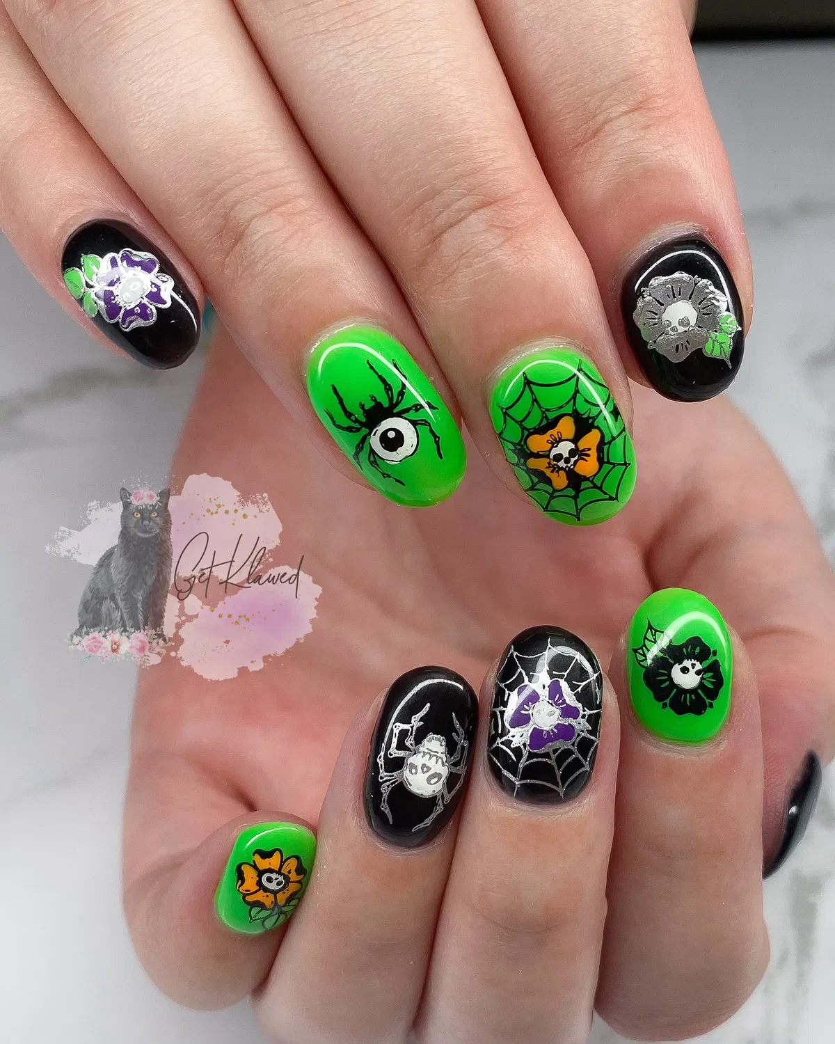 Neon green and black nails with webs, spiders, and an eyeball accent