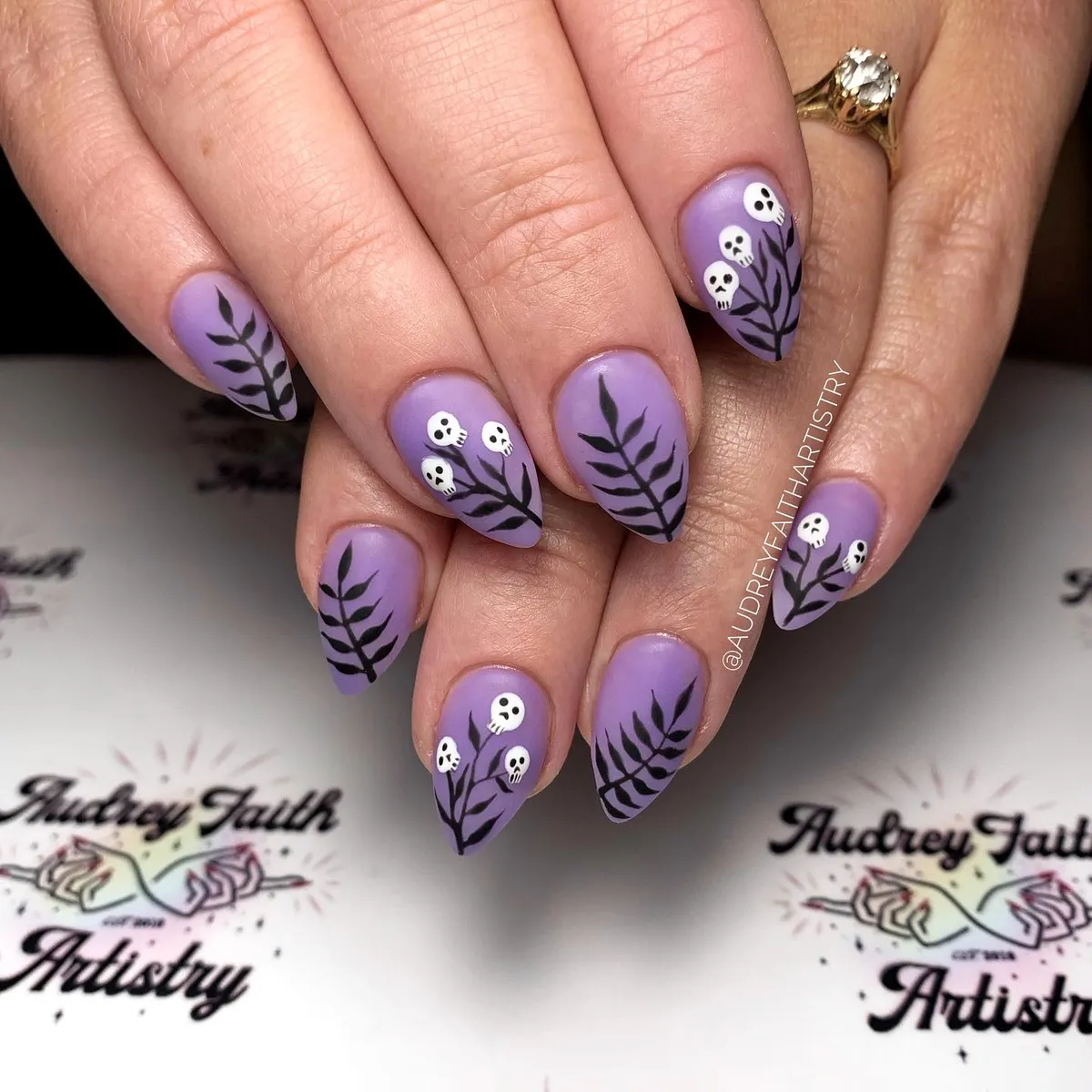 Lavender nails with black branches and tiny skulls