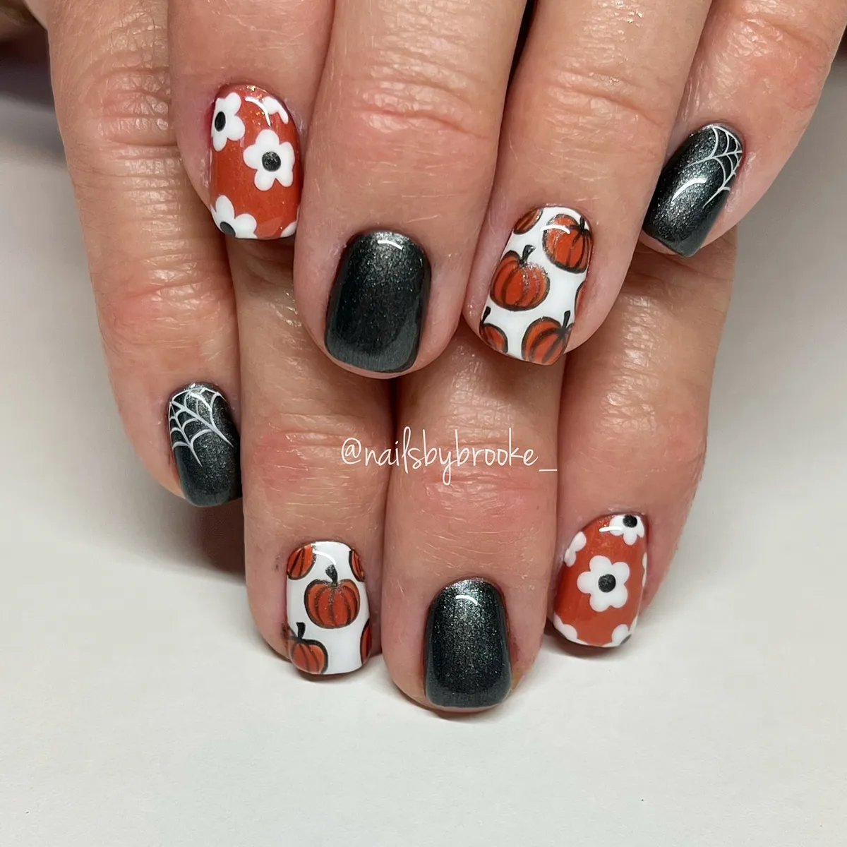 Pumpkins, daisies, and spiderweb accents in orange and charcoal