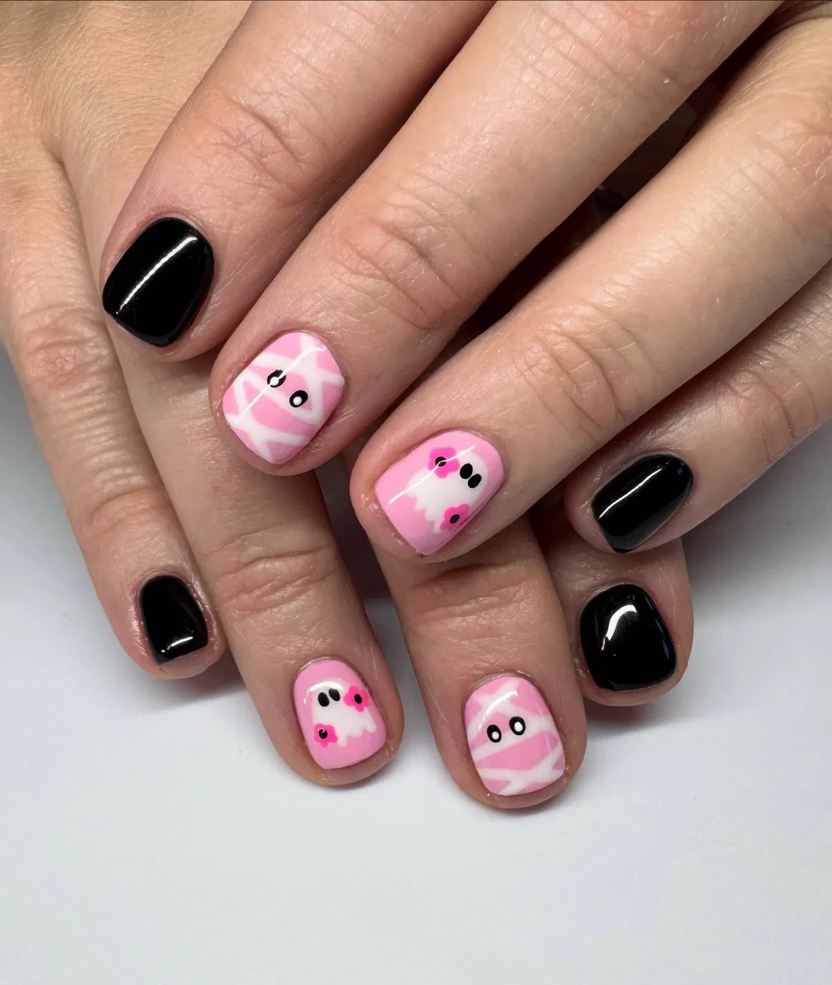 Glossy black with pink mummy wraps and tiny ghosts