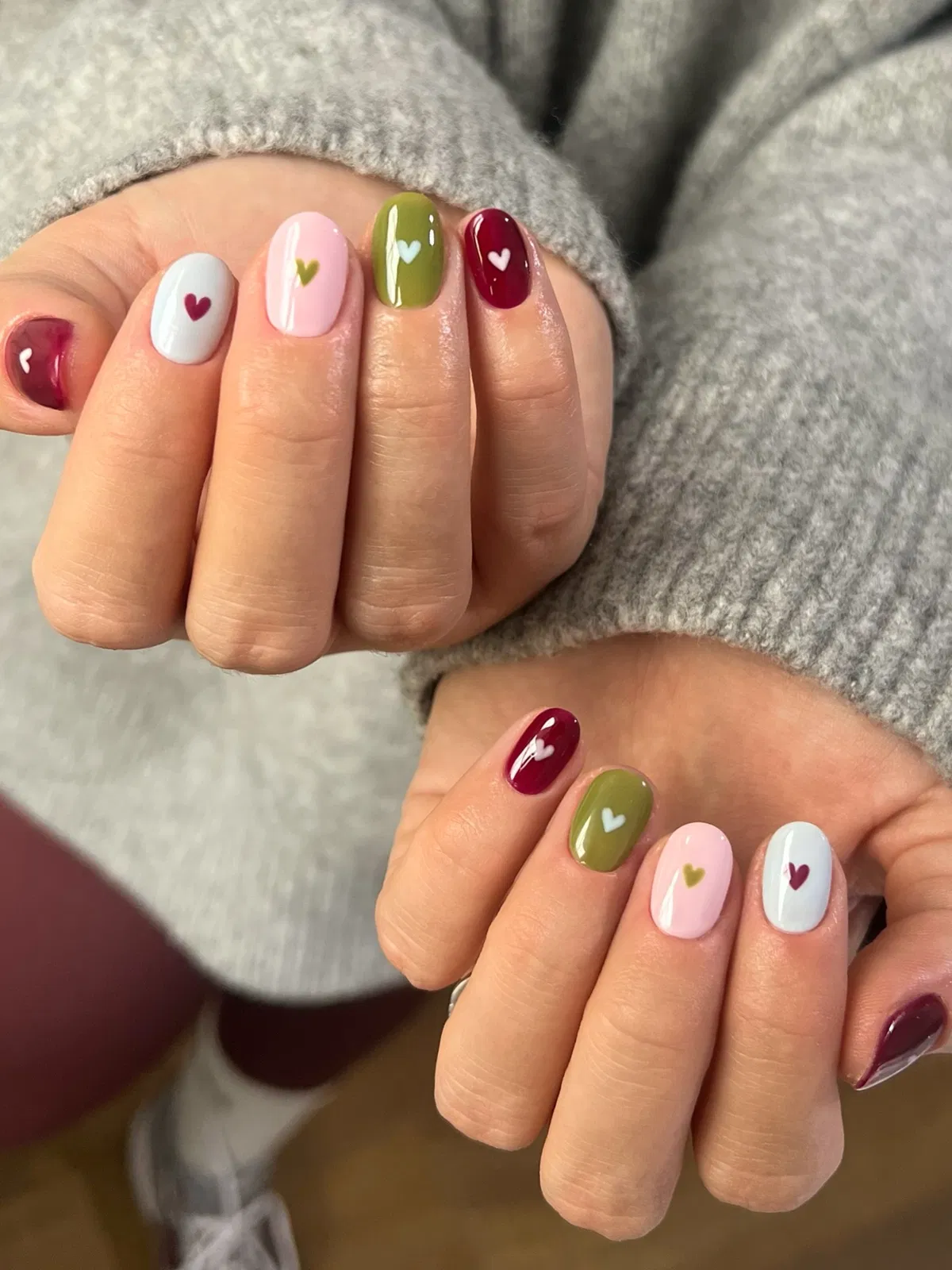 Glossy color-block nails with tiny heart motifs