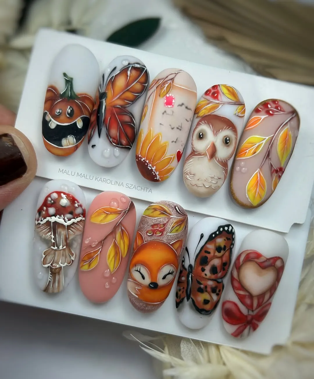 Illustrated autumn motifs on nail tip display