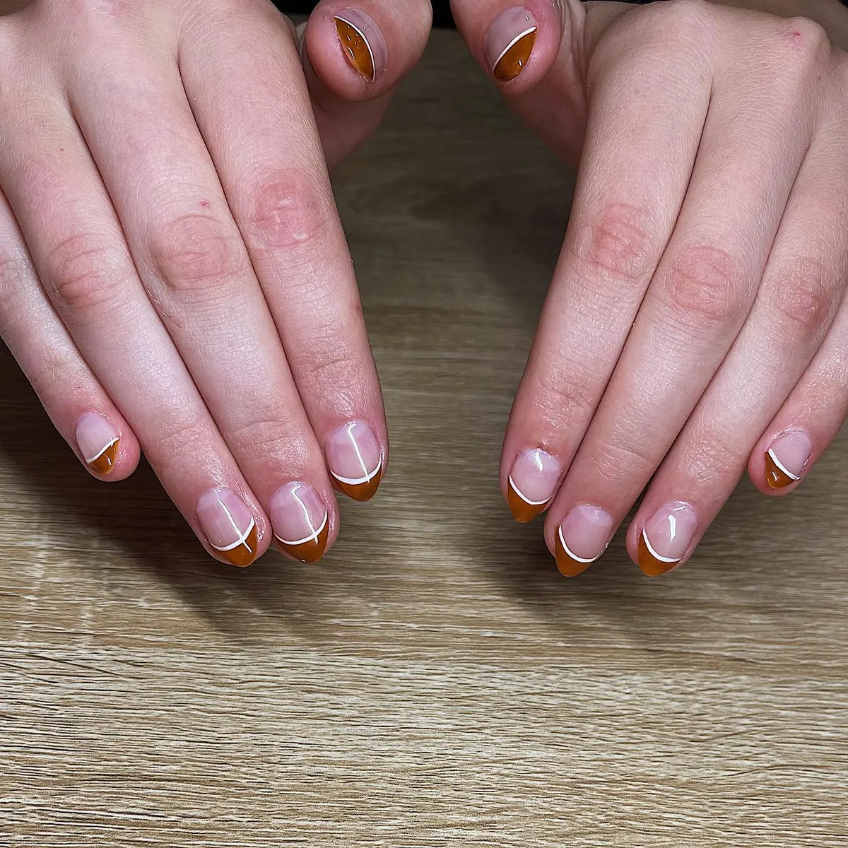 Sheer nude with curved white line and brown-orange French tips