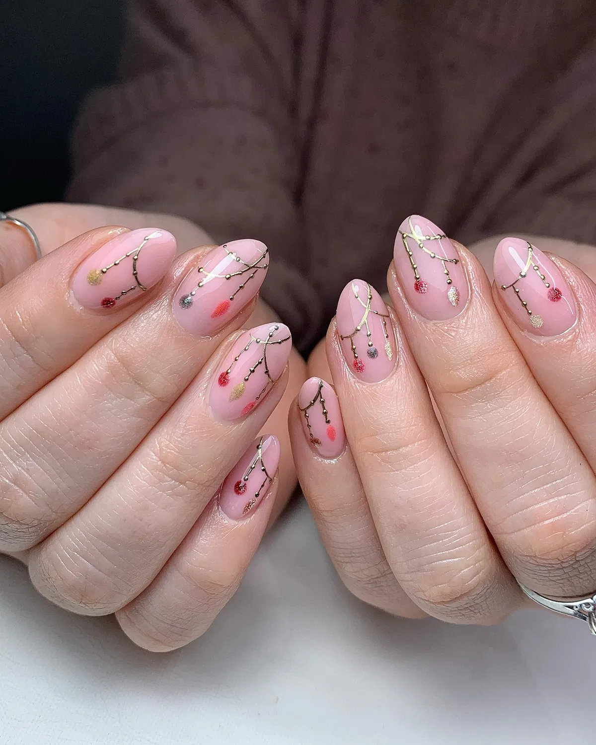 Pink nails with gold garland and ornament dots