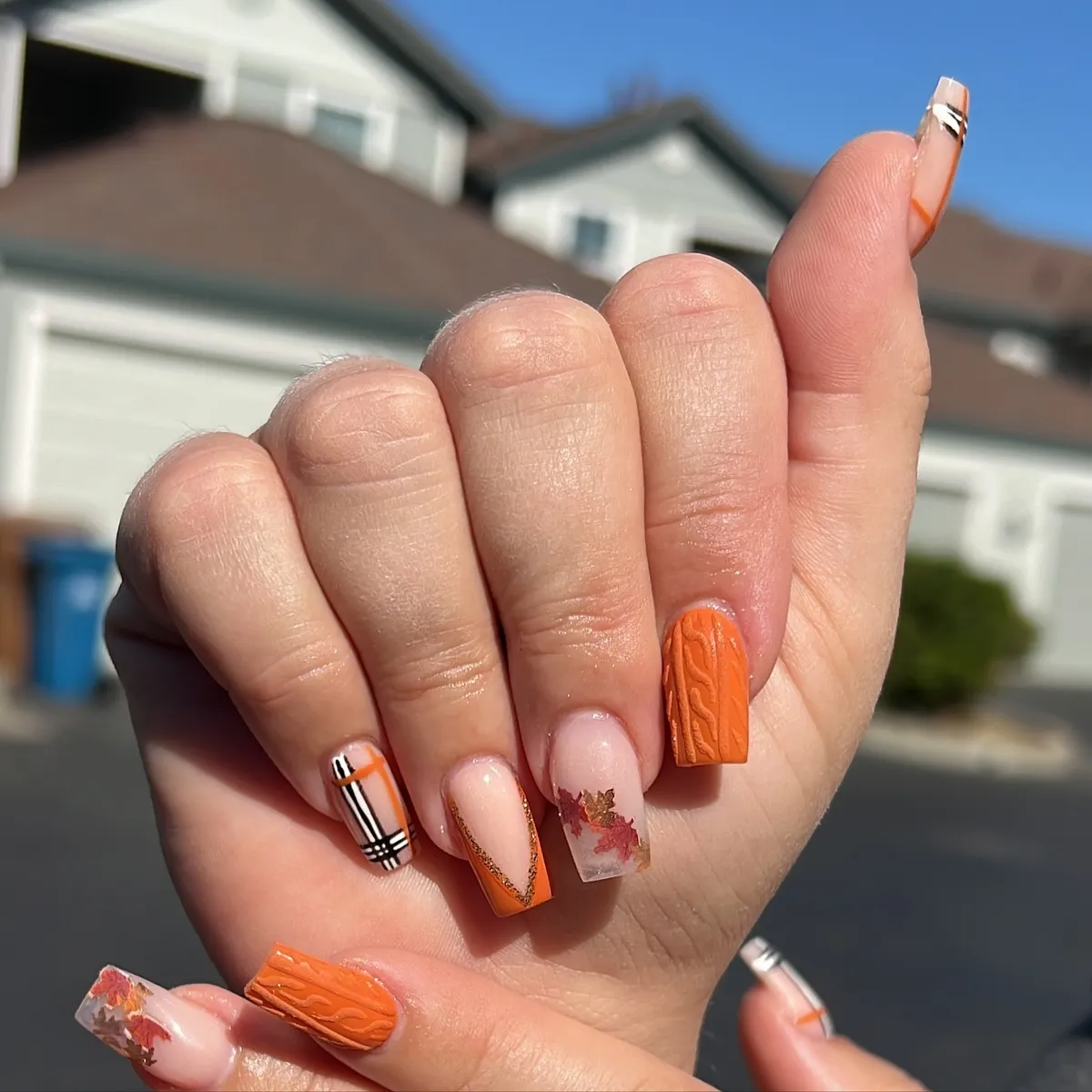 Textured orange accent with mixed French tips and embedded leaf pieces