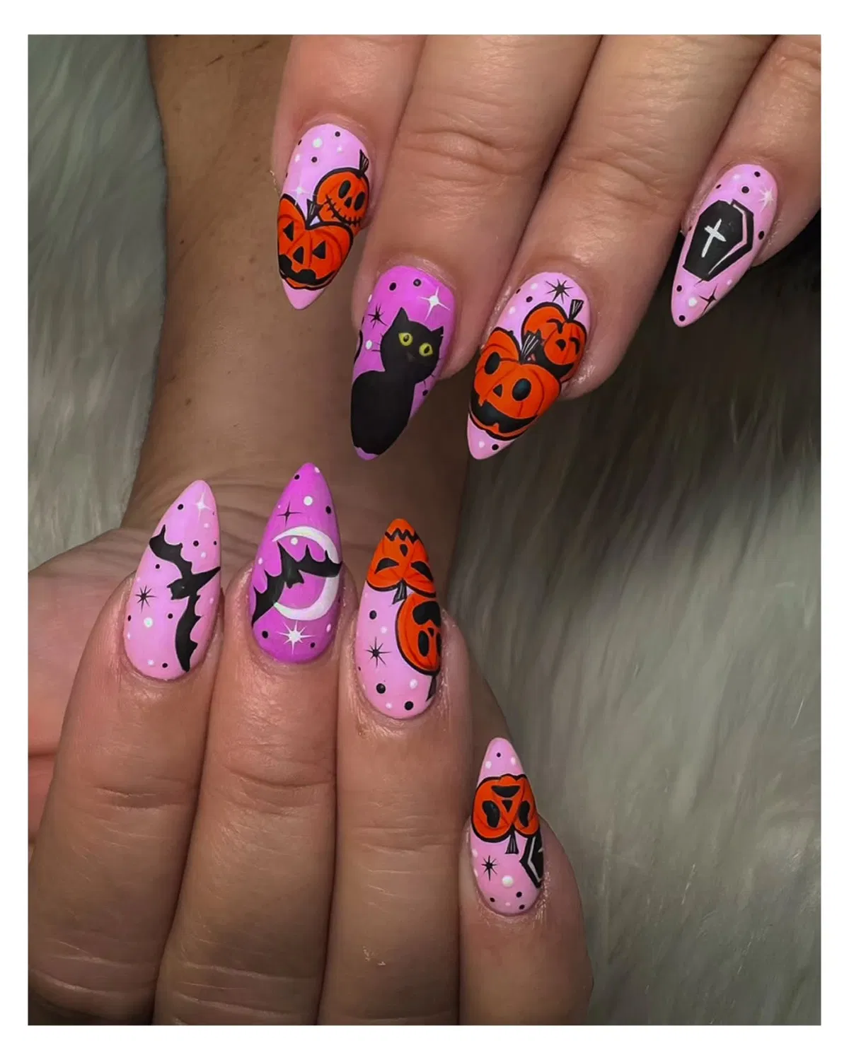 Almond pink nails with pumpkins, bats, cat, and coffin