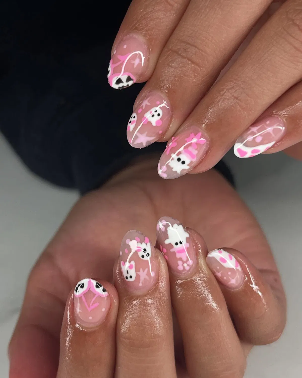 Sheer nude nails with pink-and-white ghosts and stars