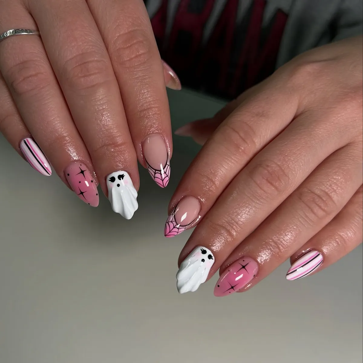 Nude-pink almond nails with 3D ghosts and web tips