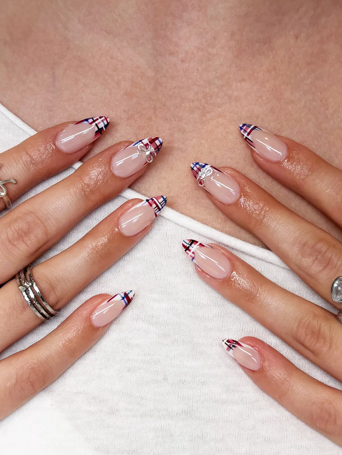 Red-and-blue plaid French tips with silver bow charms