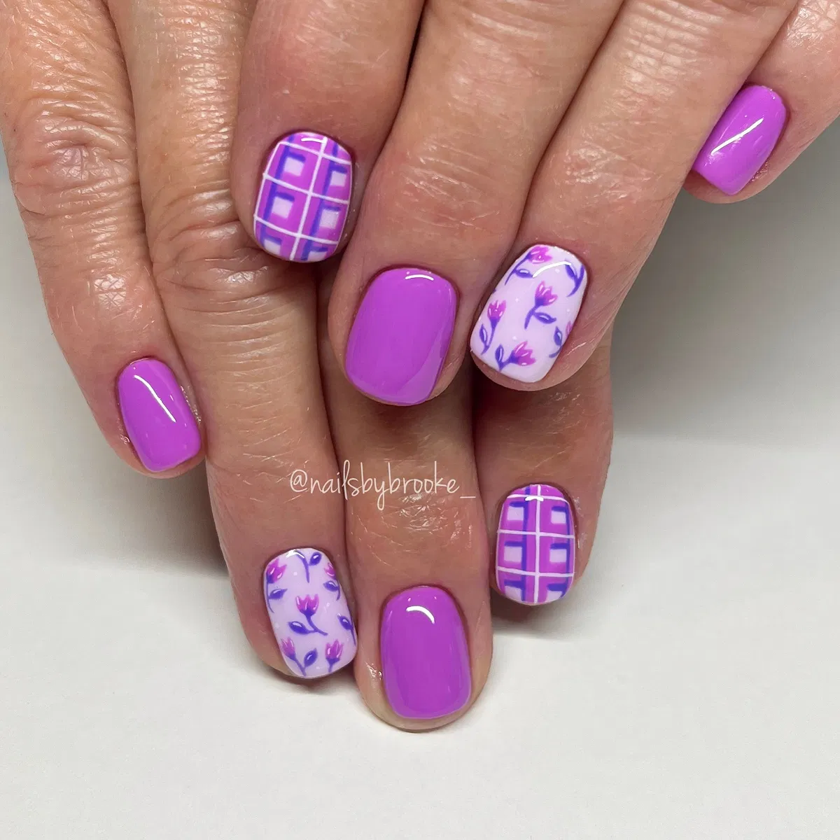 Bright purple with plaid and floral accent nails
