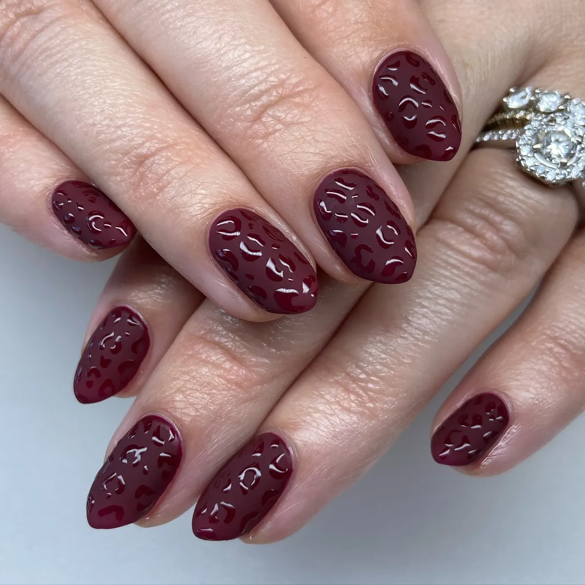 Deep burgundy gloss with textured spot pattern
