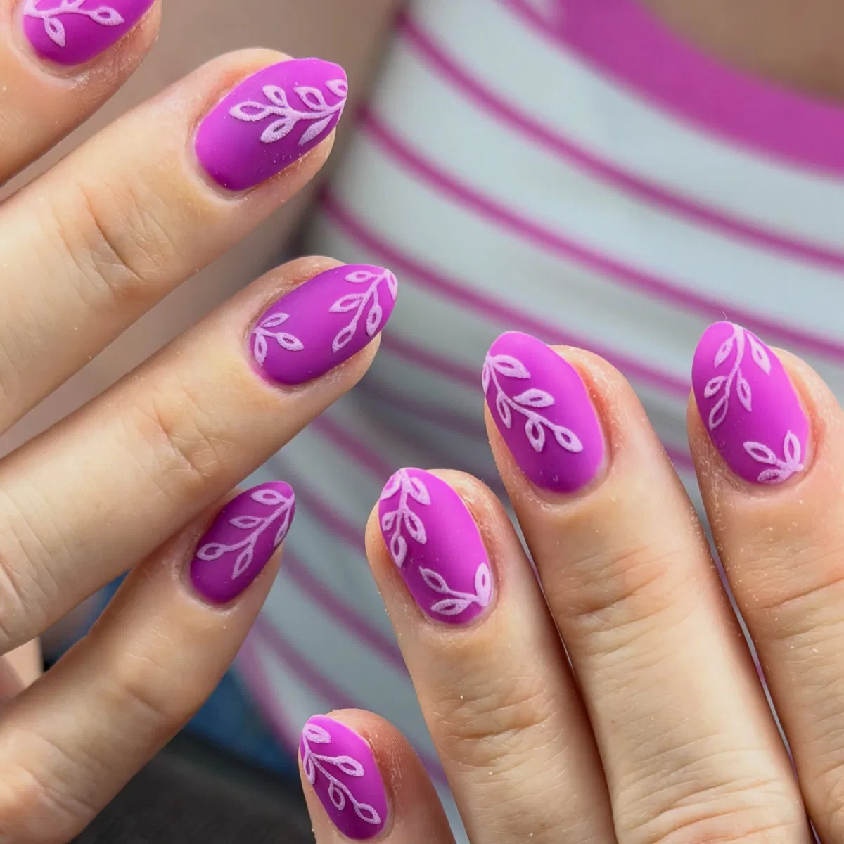 Matte pink-purple nails with white leaf motifs