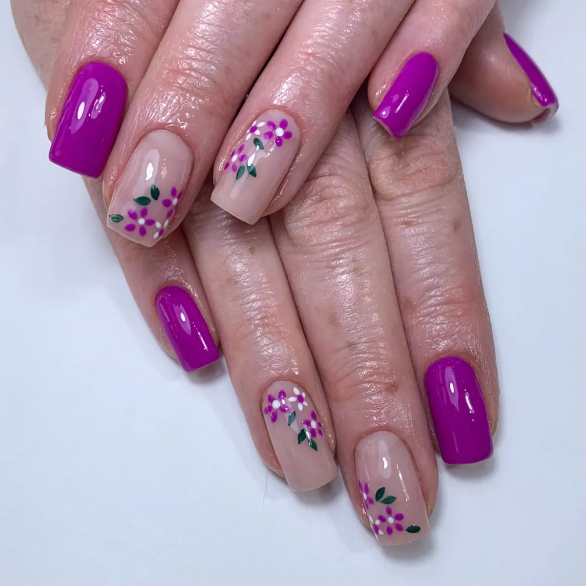 Bright purple square nails with nude floral accent nails