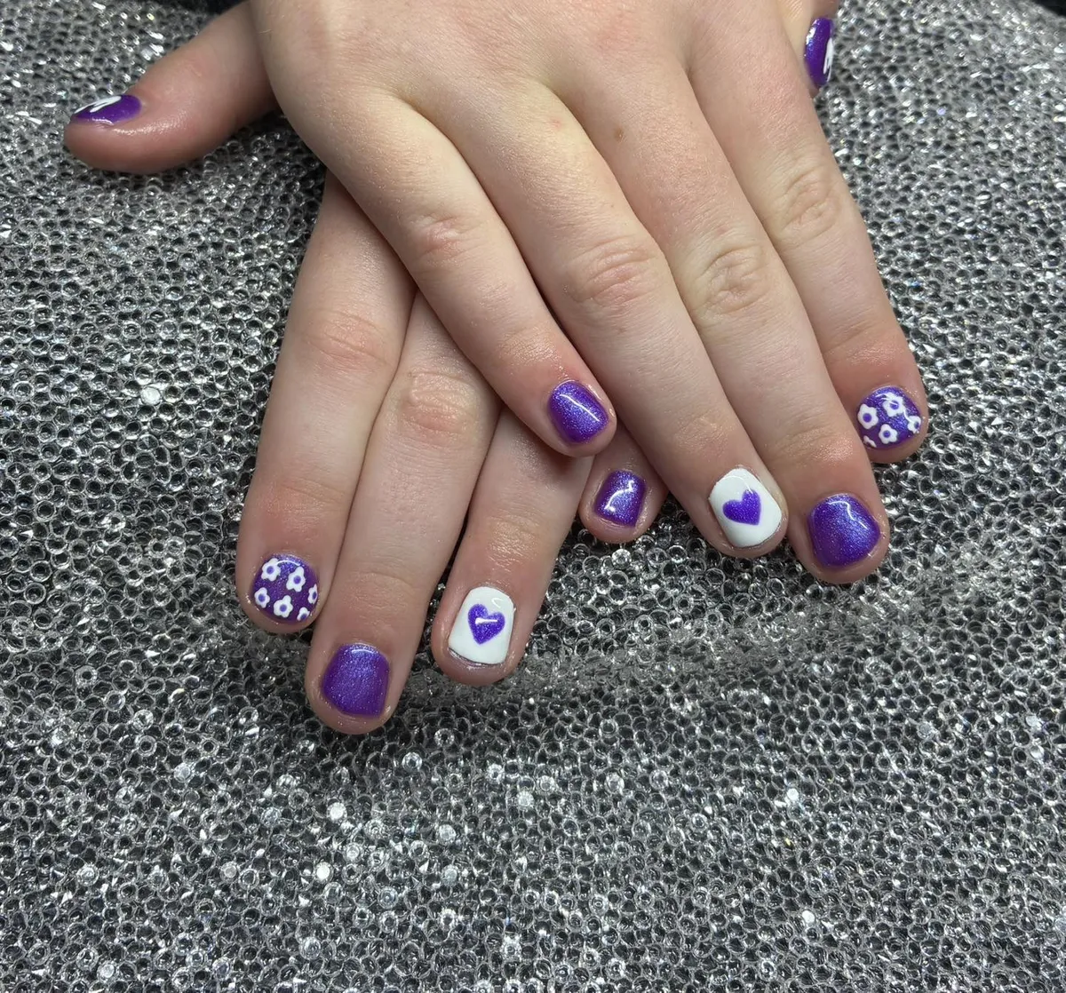 Purple shimmery pedicure with white heart accents