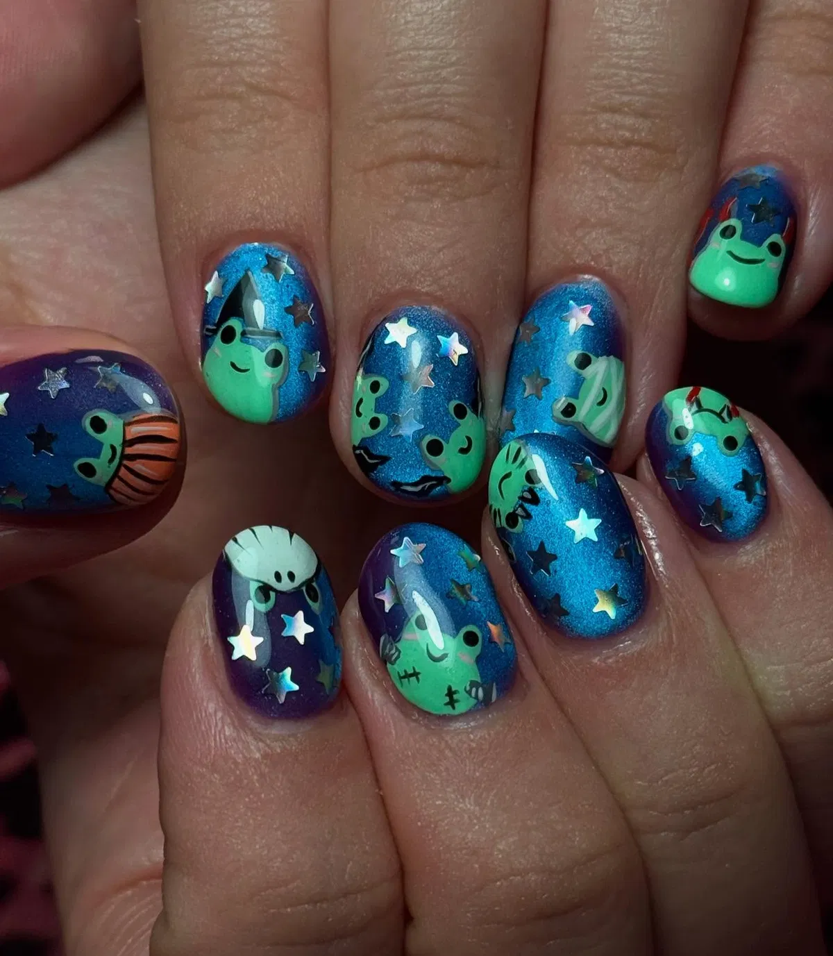 Blue-purple gradient nails with green character art and star confetti