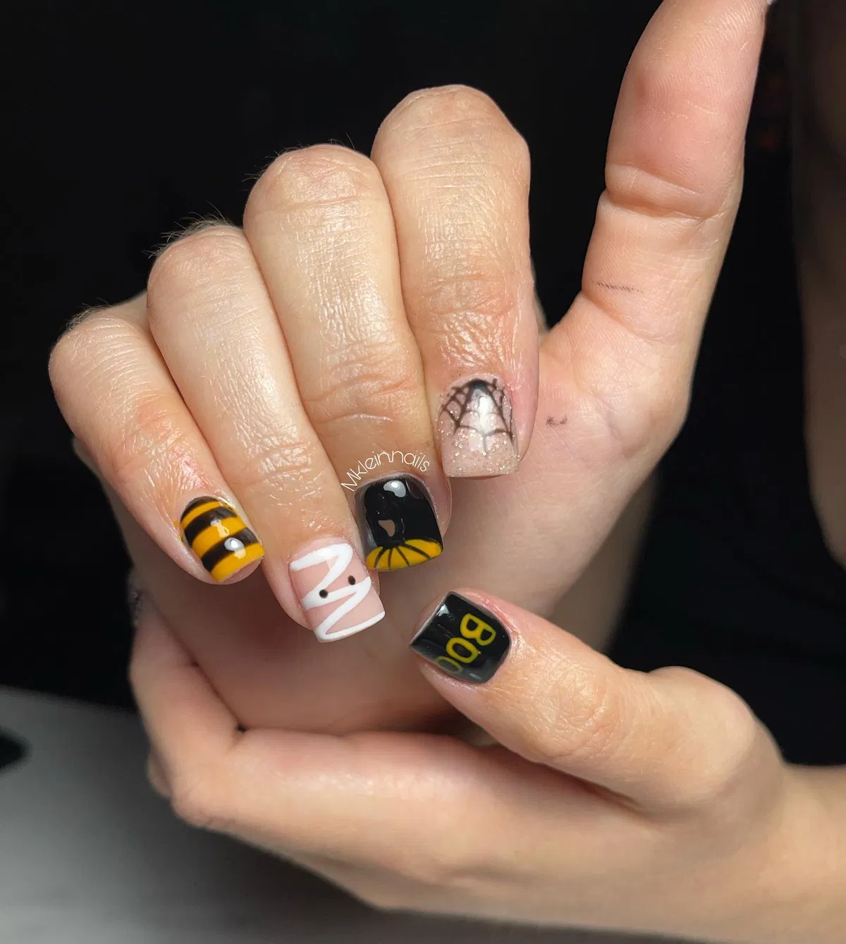 Black-and-yellow stripes with โBOOโ text and web/wrap-line accents