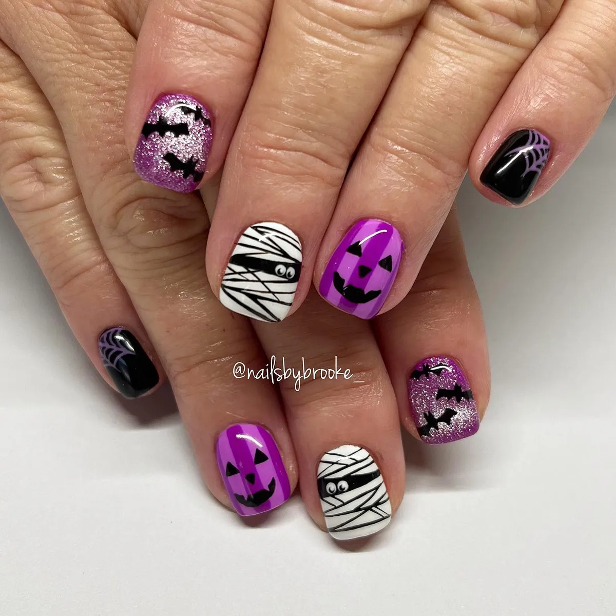 Purple glitter bats, jack-o'-lanterns, and spiderweb accents