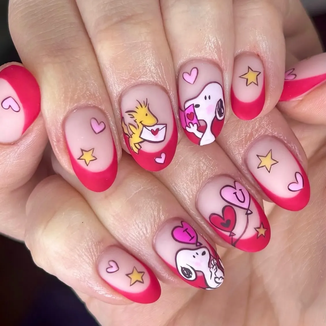 Pink French tips with hearts, stars, and cartoon art