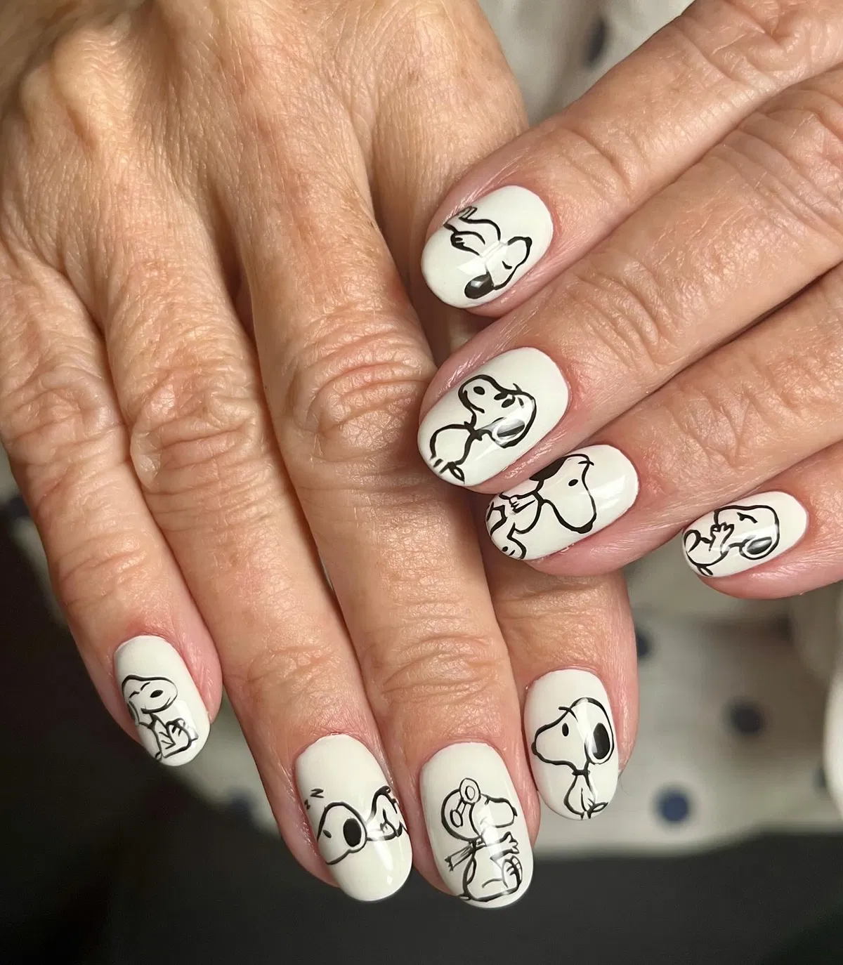 Minimal cream nails with black line-drawn cartoon dog poses