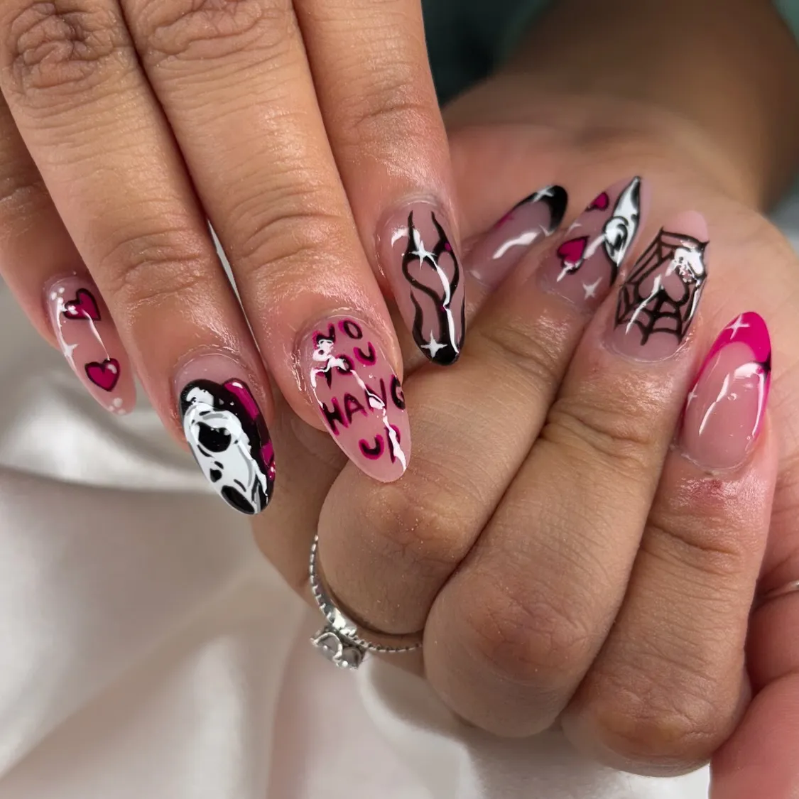 Nude-and-pink set with face art, spiderweb, and text