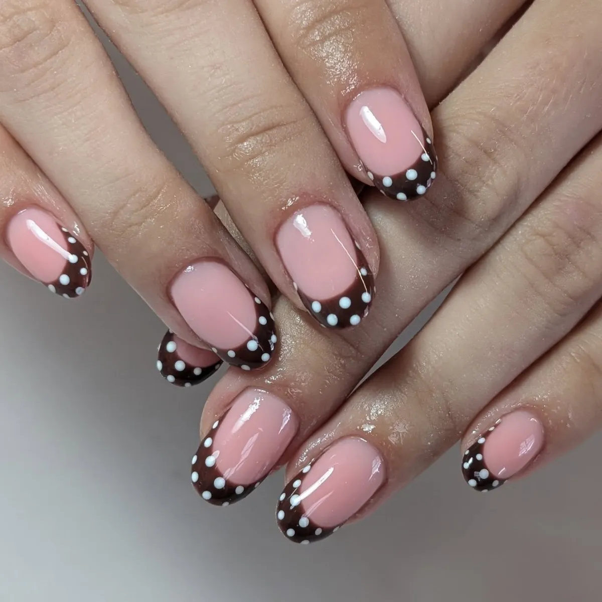 Pink base with brown French tips and white dots
