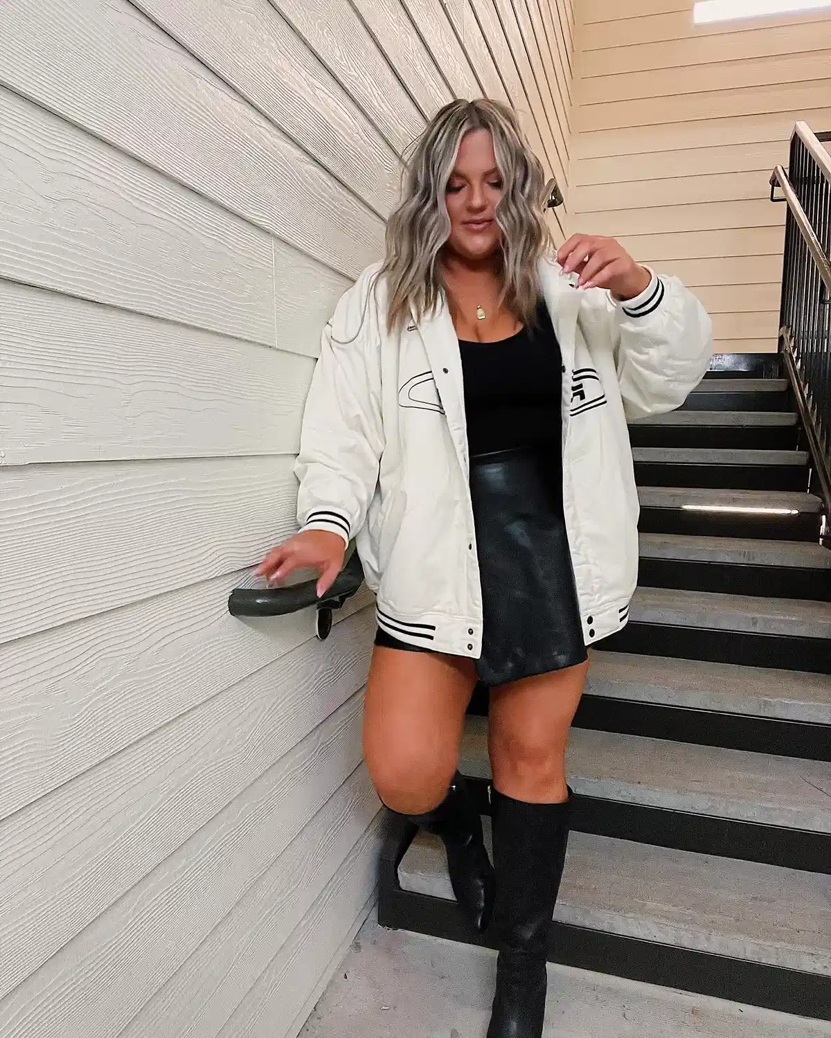 White jacket with black mini and knee-high boots