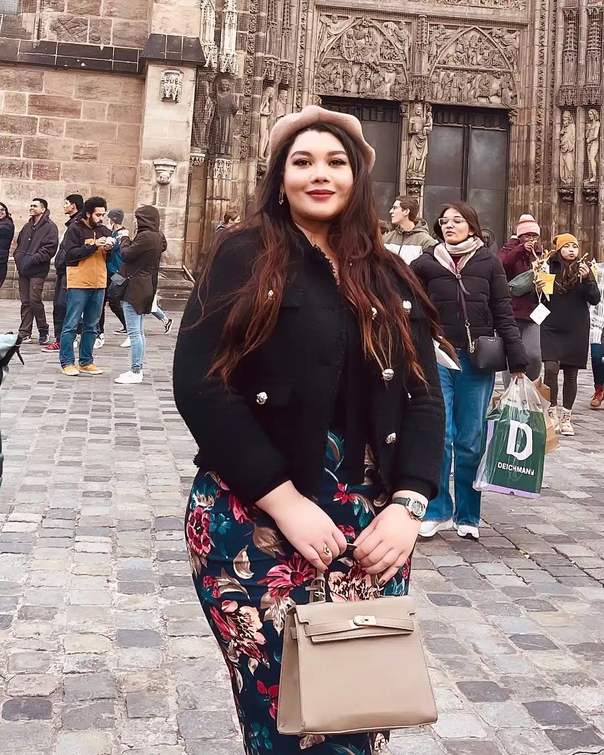 Beret with black buttoned jacket over a floral dress